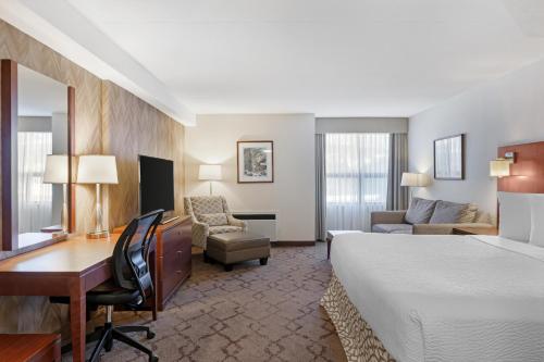 a hotel room with a bed and a desk and a computer at Best Western Plus Otonabee Inn in Peterborough