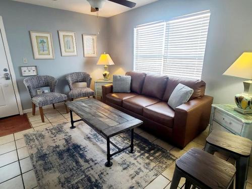 a living room with a brown couch and a table at Beautiful Views And Just Steps To The Beach - #38 Sleeps 7 in Gulf Shores