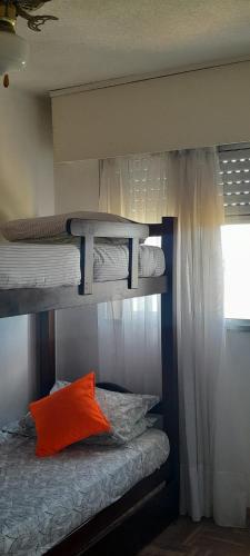 two bunk beds with an orange pillow in a room at Frente al mar in Montevideo