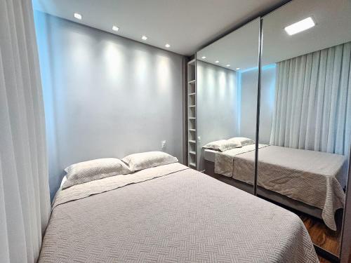 a bedroom with two beds and a mirror at Apartamento com 2 quartos a 5 minutos do centro in Brusque