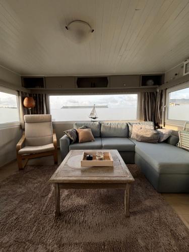 a living room with a blue couch and a table at Blue Sea Horizon in Wenduine