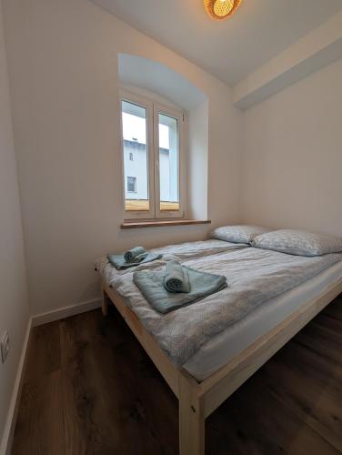 a bedroom with a large bed with a window at Apartament Podgórze Wałbrzych in Wałbrzych