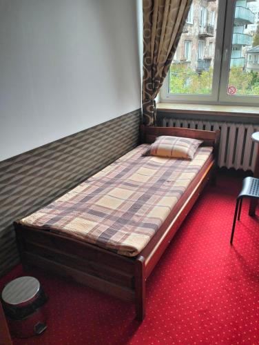 a large bed in a room with a window at Hostel Maxim in Warsaw
