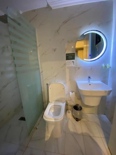 a bathroom with a toilet and a sink and a mirror at فندق منازل قباء الفندقية in Medina