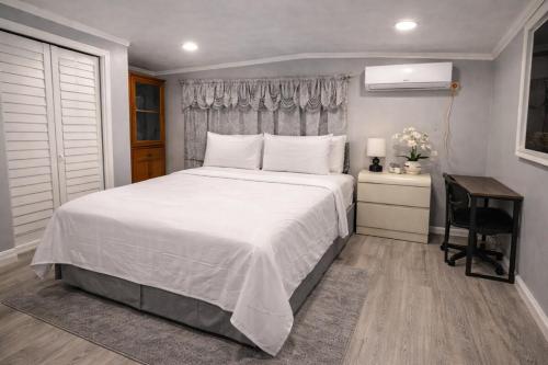 a bedroom with a large white bed and a desk at Beautiful independent suite in Brandon