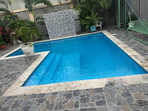 a swimming pool with blue water in a yard at Casita de las flores in San José de Ocoa