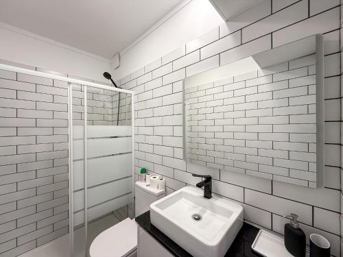 a white bathroom with a sink and a mirror at Ocean Breeze Rooms, Albufeira in Albufeira