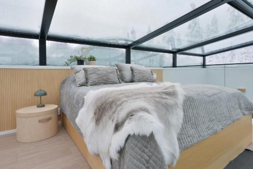 a bedroom with a bed in a room with windows at Levi Skyview Igloo in Levi