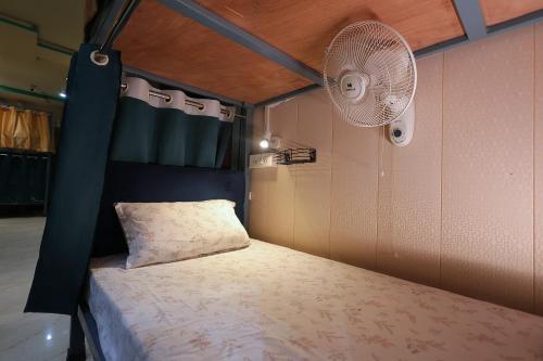 a bedroom with a bed and a fan at Laxmi Dormitory - 2 mins walk from Prem Mandir in Vrindāvan