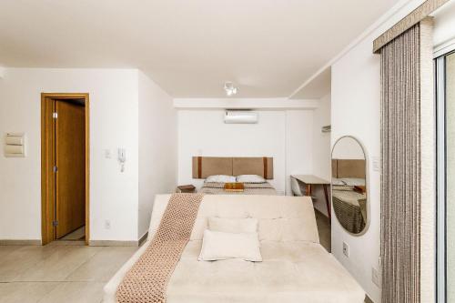 a bedroom with a bed and a mirror at Studio Harmonia Ar Cond/Centro/Piscina/Academia in Juiz de Fora