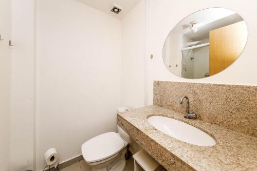 a bathroom with a toilet and a sink and a mirror at Studio Harmonia Ar Cond/Centro/Piscina/Academia in Juiz de Fora