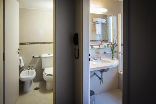 a bathroom with a toilet and a sink at Grand Brizo Comahue in Neuquén