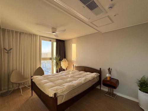 a bedroom with a large bed and a window at Surf Resort Jukdo Alive in Yangyang