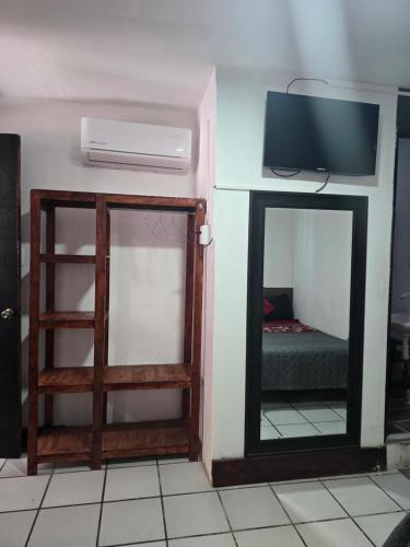 a room with a tv and a door with a mirror at Alojamiento amplio para descanso H3 in Veracruz