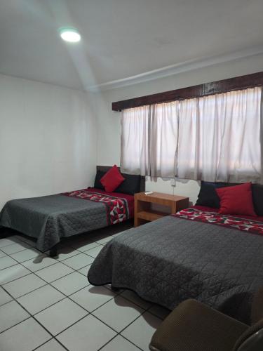 a hotel room with two beds and a window at Alojamiento amplio para descanso H3 in Veracruz