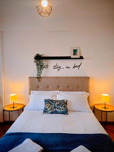 a bedroom with a bed with a sign on the wall at Harbour's way, spacious and cosy apartment, with AC in Olhão