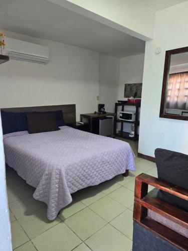 a bedroom with a bed with a purple blanket at Habitación 2 climatizada cerca de IMSS UMAE in Veracruz