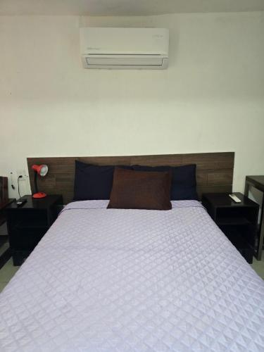 a bedroom with a bed with a white comforter at Habitación 2 climatizada cerca de IMSS UMAE in Veracruz