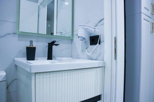 a bathroom with a white sink and a mirror at Amiri Lux Suites in Shkodër