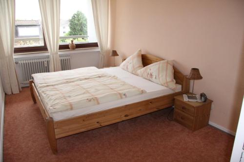 a bedroom with a wooden bed with a window at FeWo Bonn Sejour - Nähe UN-Campus u. WCCB in Bonn