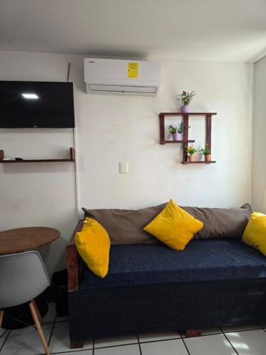 a couch in a room with yellow pillows on it at Habitación amplia climatizada LuzSerena #9 in Veracruz