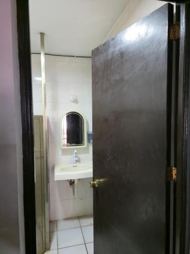 a bathroom with a sink and a metal door at Habitación amplia climatizada LuzSerena #9 in Veracruz