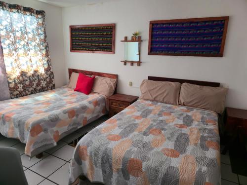 a bedroom with two beds and a window at Habitación amplia climatizada LuzSerena #9 in Veracruz
