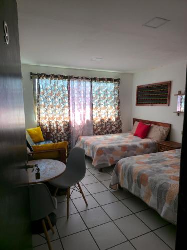a room with two beds and a couch and a table at Habitación amplia climatizada LuzSerena #9 in Veracruz