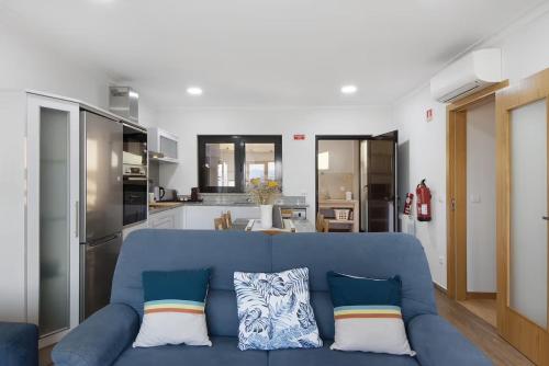 a living room with a blue couch and a kitchen at Quinta do Sonho in Resende