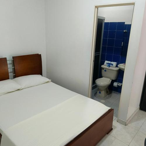 a bedroom with a bed and a bathroom with a toilet at Hotel BSJ Neiva in Neiva