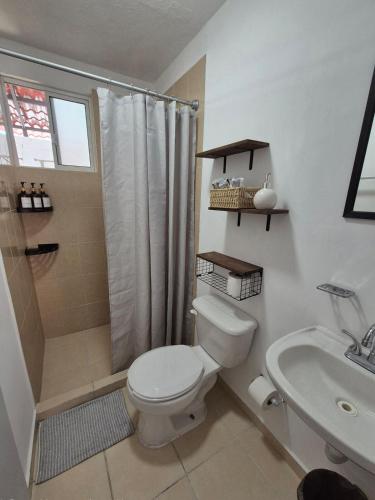 a bathroom with a toilet and a shower and a sink at Casa Luna TX in Tequisquiapan