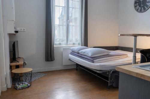 a hospital bed in a room with a window at La petite cour in Beaune