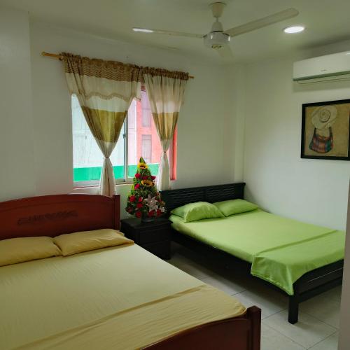 a room with two beds and a christmas tree in it at Hotel BSJ Neiva in Neiva