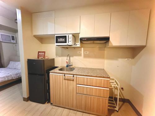 a small kitchen with a sink and a refrigerator at Cozy maple grove studio with hot shower in General Trias