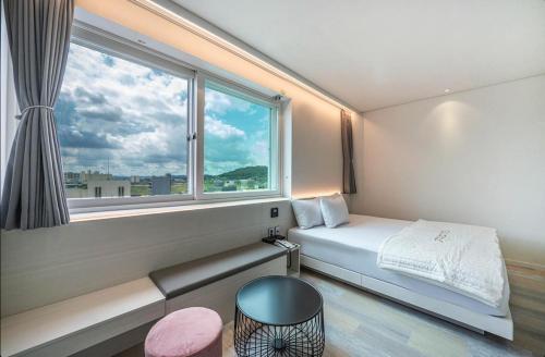 a room with a bed and a large window at Daegu Innovation City Stay22 in Panyawŏl-yŏk