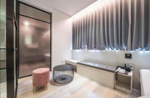 a bathroom with a bench and a table and a chair at Daegu Innovation City Stay22 in Panyawŏl-yŏk