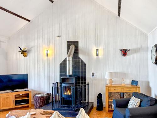a living room with a fireplace in the wall at The Heron in Ardentinny