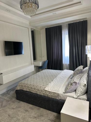 a bedroom with a bed and a flat screen tv at Luxury Apartment Tashkent City boulevard Happy Home in Tashkent