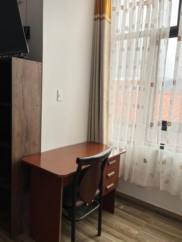 a wooden desk with a chair next to a window at Aparthotel Cusco in San Antonio