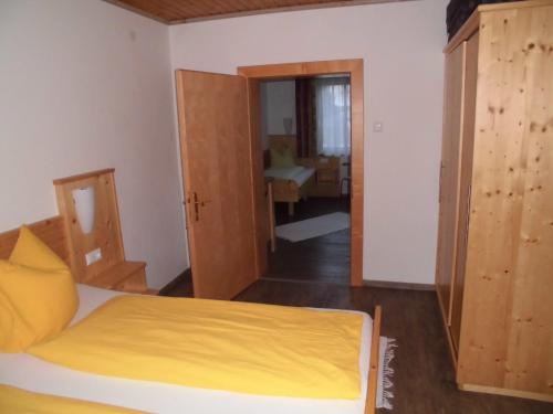 a bedroom with a bed and a door to a bathroom at Pension & Ferienwohnung Dullnig in Gmünd in Kärnten