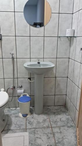 a bathroom with a sink and a mirror and a toilet at Hotel Capim Dourado in Palmas