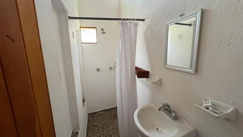 a white bathroom with a sink and a mirror at Hotel Frida Paradise in Brisas de Zicatela