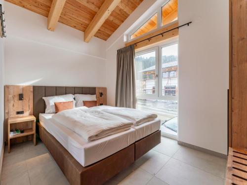a bedroom with a bed and a large window at Grebenzen Lodges 49B in Sankt Lambrecht