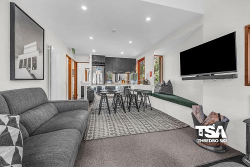 a living room with a couch and a tv at Mosswood 2 in Thredbo