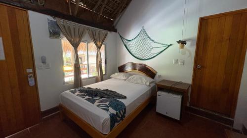 a small bedroom with a bed and a window at Hotel Frida Paradise in Brisas de Zicatela