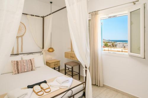 a bedroom with a bed and a large window at Louros rooms in Koufonisia