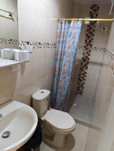 a bathroom with a toilet and a sink and a shower at Nora's Casa de familia Laureles in Medellín