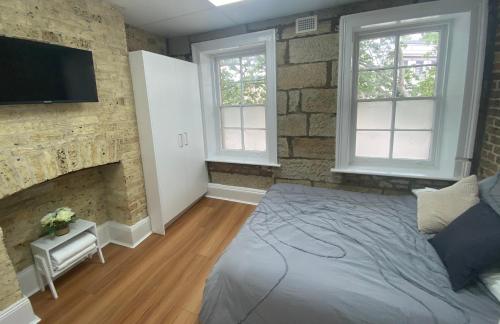 a bedroom with a large bed and a fireplace at 2 Bedroom Pyrmont Terrace House in Sydney