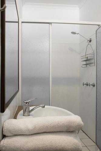 a white bathroom with a sink and a shower at The Moonie Crossroads Hotel in Moonie
