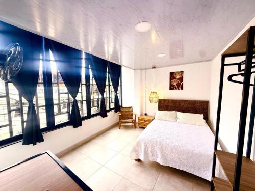 a bedroom with a bed and a large window at Toba hotel boutique in Ibagué